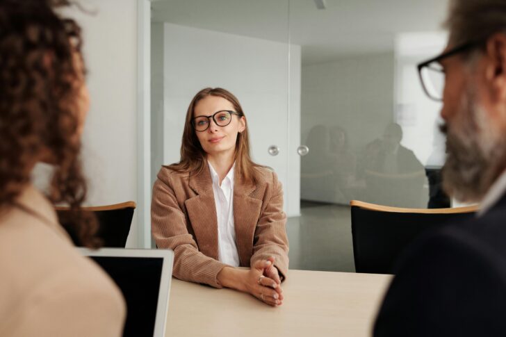 Young woman attending a job interview in a modern office, showcasing confidence and professionalism.